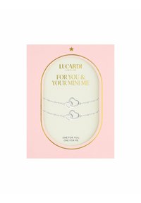 Zilveren hartvormige armbanden gepresenteerd in een roze en gouden doos. Tekst bevat "VOOR JOU EN JE MINI ME" en "ÉÉN VOOR JOU, ÉÉN VOOR MIJ."