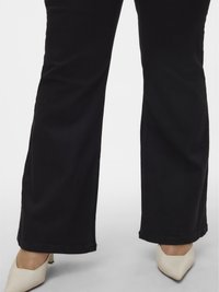 Zwarte katoenen wijde broek met een gladde textuur, voorzien van contrasterende stiksels en een losse pasvorm, gecombineerd met puntige beige hakken.