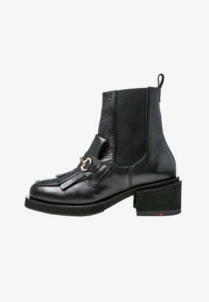 Bottine en cuir noir avec talon bloc, panneau latéral élastique, détail à franges et boucle métallique argentée à l'avant.