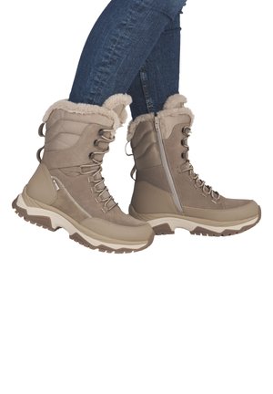 Bottes imperméables beige avec bord en fausse fourrure, tissu texturé et lacets, dotées d'une fermeture éclair latérale et d'une semelle épaisse et durable.