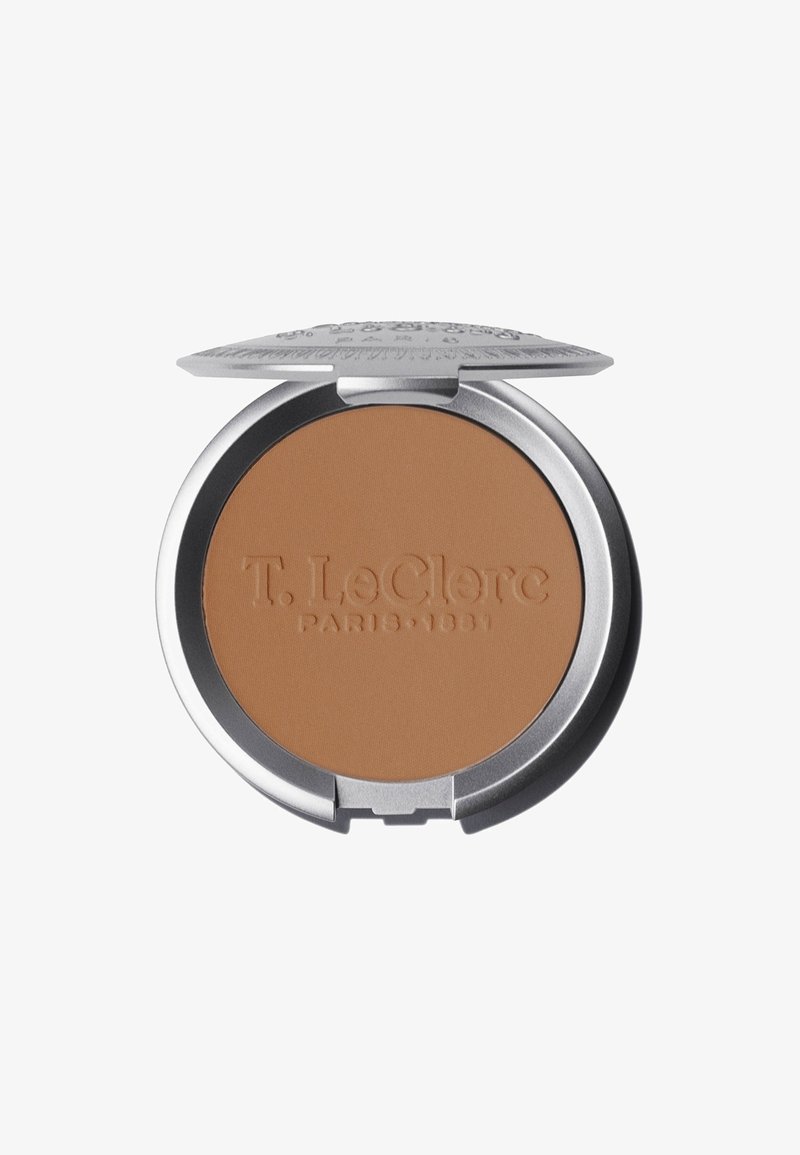 Kompakter Bronzer mit einem runden, silbernen Gehäuse und einem strukturierten, gravierten Deckel. Das Puder hat einen matten Braunton ohne sichtbaren Schimmer.