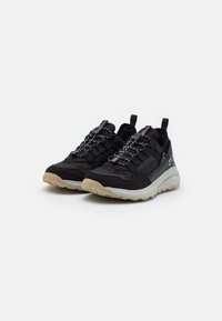 Scarpe da ginnastica nere con una tomaia in tessuto texturizzato, sistema di allacciatura e una suola spessa di un grigio chiaro. Include linguette sul tallone per una facile vestibilità.