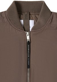 Veste bomber marron avec col côtelé, fermeture éclair argentée et tirette noire portant l'inscription "CECIL OUTERWEAR".