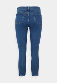 Blå denimjeans med en figurnära design, har två bakfickor och en medelhög midja, avslutade med standardstickning.