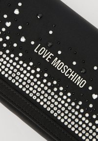 Portafoglio nero con file di strass neri e argento, con il testo "LOVE MOSCHINO" bene in evidenza in metallo argentato.