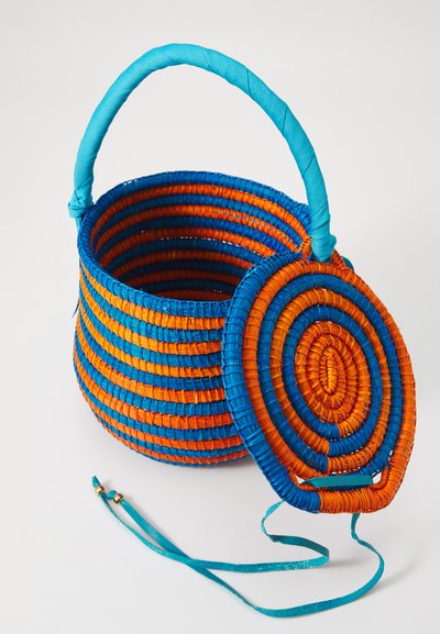 Woven basket with a round shape, featuring blue and orange stripes, a matching circular lid, and a turquoise handle wrapped in fabric.
