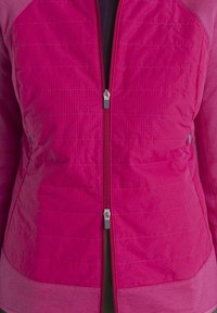 Veste matelassée rose vif avec deux curseurs de fermeture éclair argentés visibles, portée sur un vêtement noir.