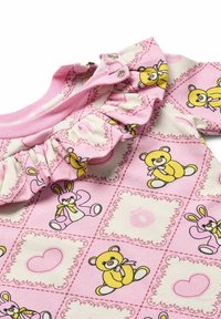 Rosa Stoff mit Bären- und Hasenmuster; mit Rüschenausschnitt und Druckknopfverschluss. Weiches Baumwollmaterial mit glatter Textur.