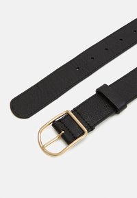 Ceinture en cuir noir avec une finition texturée, dotée d'une boucle en métal doré et de plusieurs trous pour l'ajustabilité. Design simple et fonctionnel.