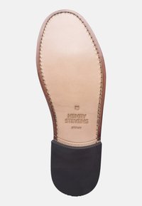 Sole di scarpa in pelle marrone con una soletta liscia color cuoio dotata di nome del brand impresso, dettagli di cucitura lungo il bordo e un tacco in gomma nera.