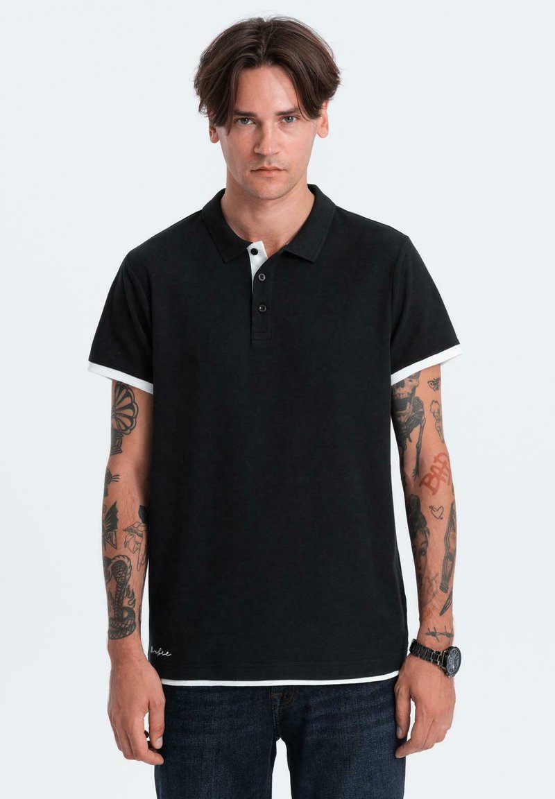 Černé polo tričko s bílým límečkem a krátkými rukávy. Má tříknoflíkovou légu a je vyrobeno z texturované látky.