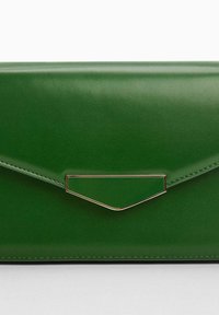 Pochette enveloppe en cuir vert à texture lisse, ornée d'un détail en métal doré et de bords cousus. Design compact et anguleux.