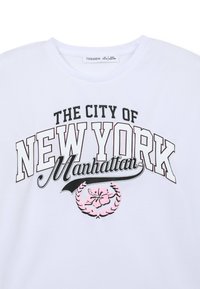 T-shirt bianco in cotone con "LA CITTÀ DI NEW YORK" in nero, "Manhattan" in corsivo e un design floreale rosa all'interno di un alloro.