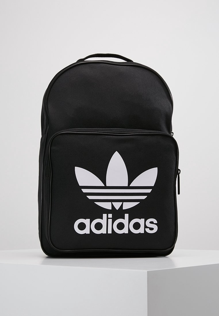 Black backpack made of durable fabric, featuring a large white Adidas logo on the front pocket and a rounded top with a top handle.