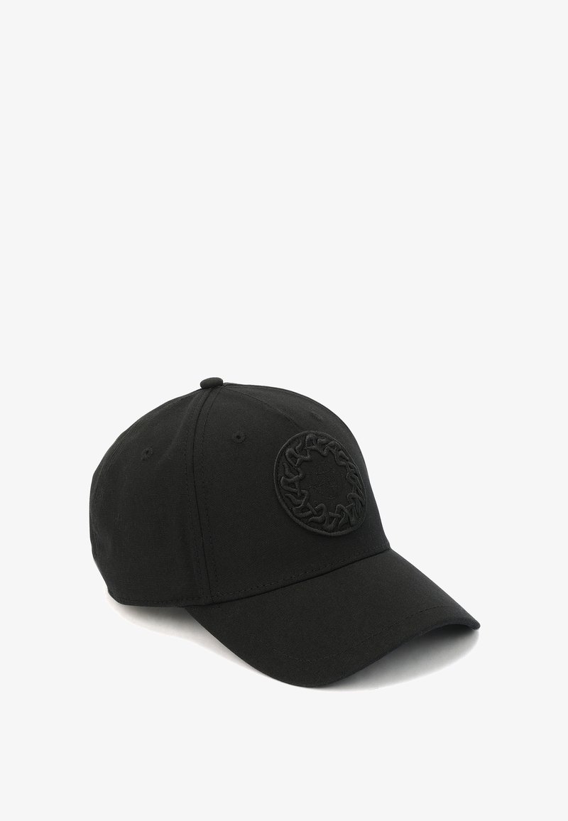 Gorra negra con visera curva, hecha de tela, que presenta un logotipo circular texturizado en la parte frontal. Diseño simple sin acentos adicionales.