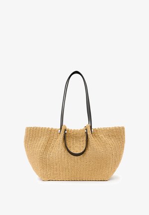 Borsa a rete in paglia beige, con manici in pelle nera e accessori in metallo argentato. Forma spaziosa e curvata con superficie testurizzata.