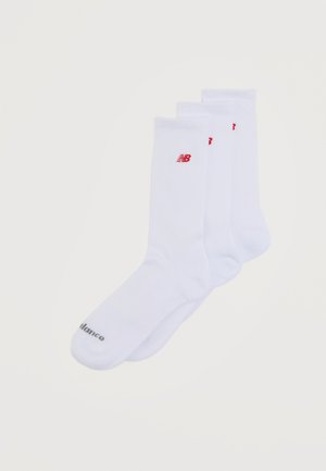 Trei perechi de șosete albe până la gleznă cu logo roșu New Balance aproape de vârf și text negru "Balance" pe zona degetelor.