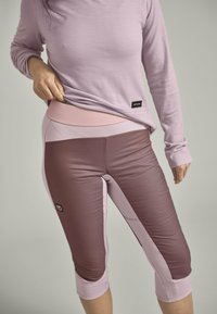 Light purple long-sleeve top paired with fitted, three-quarter length leggings featuring a gradient of pink and brown shades and a waistband detail.