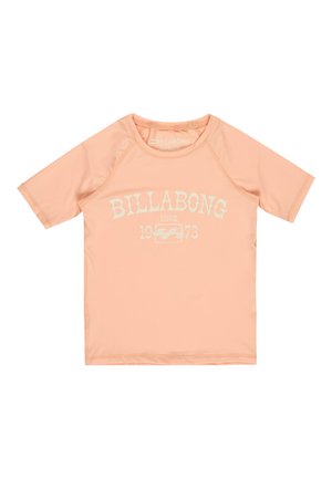 Brzoskwiniowa koszulka z krótkim rękawem Billabong typu rash guard z białym napisem "BILLABONG SINCE 1973" i logo fali na przodzie, z okrągłym dekoltem.