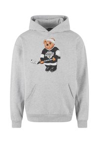 Grå hættetrøje med et bjørnegrafik iført hockeyudstyr, der holder et hockeyslag. Leveres med en frontlomme og ribbede manchetter.