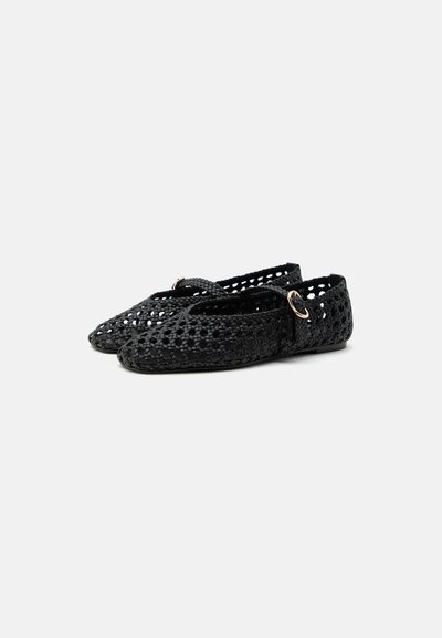 Chaussures plates tissées noires à bouts pointus, une bride sur le dessus fermée par une petite boucle dorée et des semelles à talons bas.