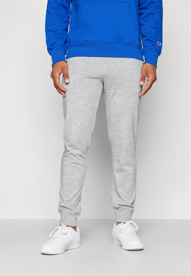 Gray sweatpants with a soft texture, fitted design, and elastic cuffs; paired with white sneakers and a blue hoodie.