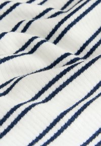 Bombažno blago z izmeničnimi mornarsko modrimi in belimi vodoravnimi črtami, z izrazito teksturo in mehkim rebrastim dizajnom.