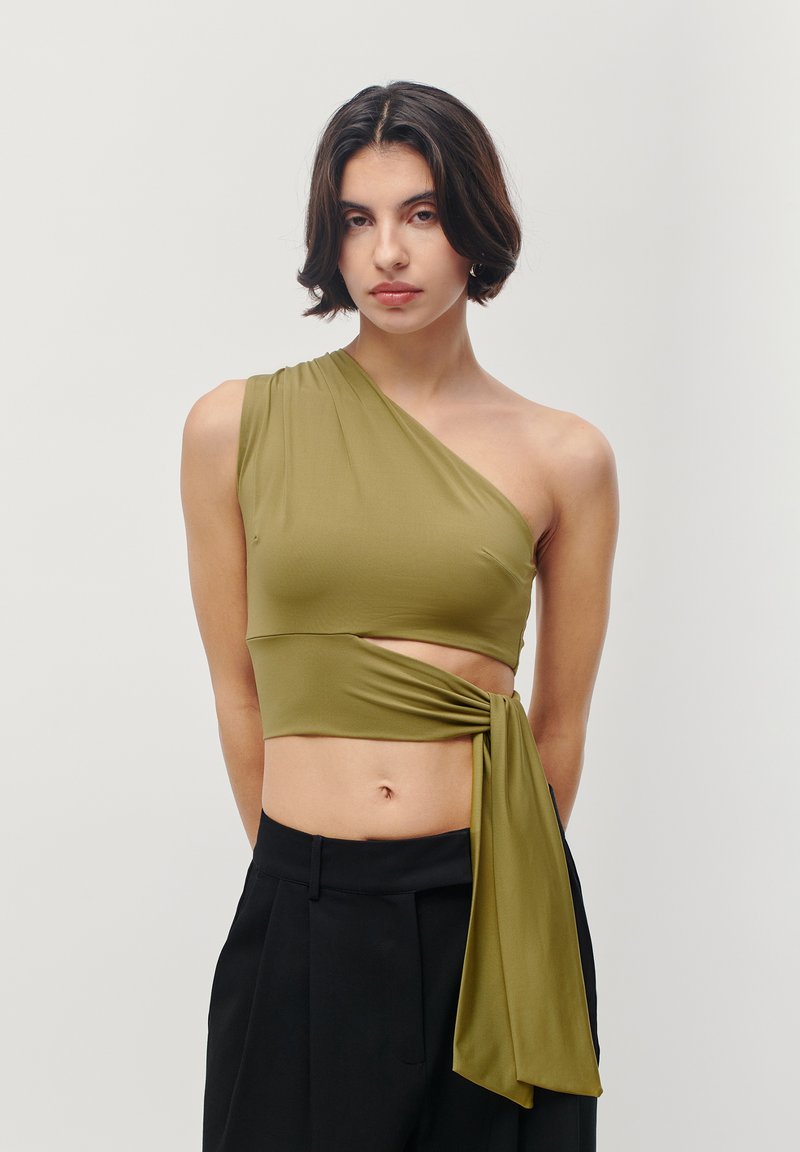 Olive green, one-shoulder crop top with a twist design at the waist, made of smooth fabric. Features a tied accent on the side.