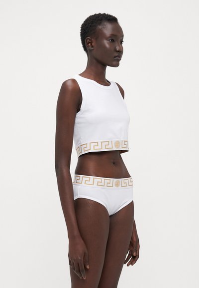 Bílý bavlněný crop top a bikiny, se zlatým vzorem řeckého klíče na pásku. Hladká textura, přiléhavý střih.