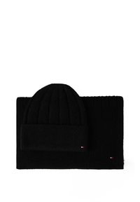 Czarny zestaw czapki beanie i szalika, z prążkowaną teksturą, z podwiniętym mankietem na czapce oraz minimalnymi akcentami logo na obu elementach.