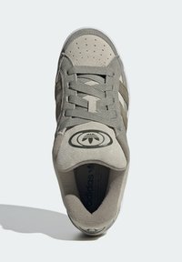 Graue Wildledersneaker mit strukturiertem Stoff, durchlöchtem Zehenbereich, genähten Akzenten und Logo auf der Zunge; ausgestattet mit flachen Schnürsenkeln und weißer Gummisohle.