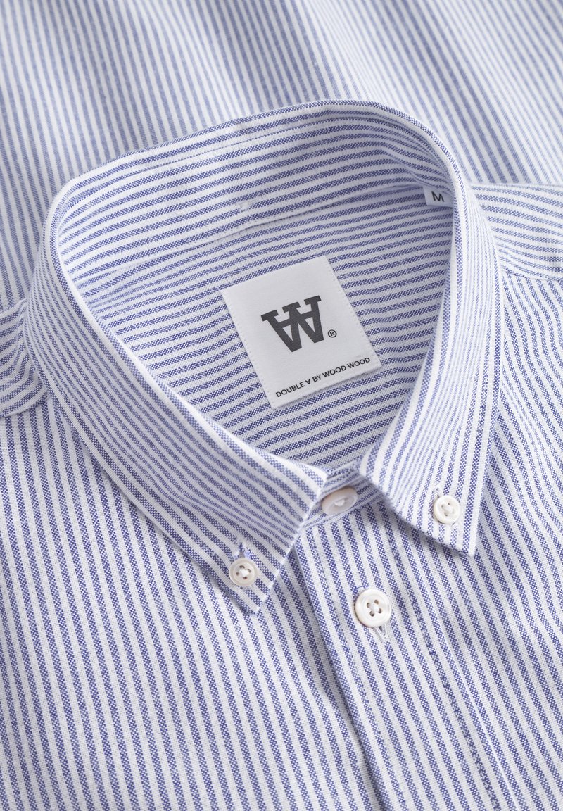 Camisa a rayas azul y blanca con cuello abotonado, botones blancos y una etiqueta que dice "DOUBLE W by WOOD WOOD."