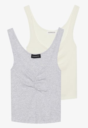 Two tank tops: one light gray with a textured pattern and front buttons, and one solid cream. Both have wide straps and a scoop neckline.
