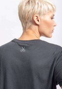 Grijze katoen t-shirt met een schaar graphic gestikt in lichtgrijs op de achterkant van de halslijn, met een ontspannen pasvorm en zachte textuur.