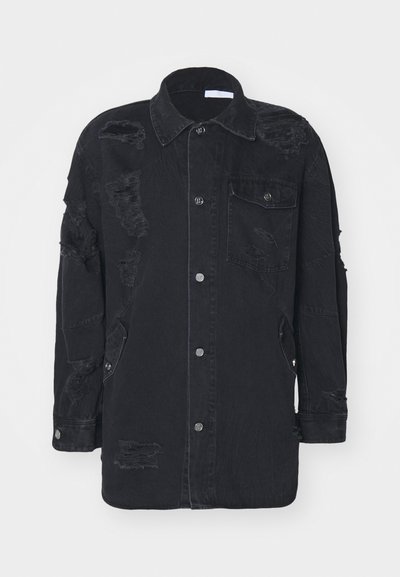 Schwarze Jeansjacke mit distressed Details, Knopfverschluss, Kragen und seitlichen Taschen. Strukturierter Schnitt mit leicht oversized Passform.