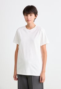 Hvid bomulds T-shirt med korte ærmer og rund halsudskæring, der har en afslappet pasform og glat tekstur.