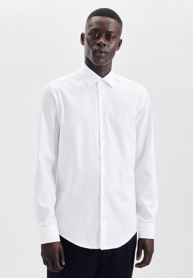 Witte lange mouwen shirt gemaakt van gladde stof, met een klassieke kraag en knoopsluiting aan de voorkant, met afgeronde zoom en aansluitende mouwen.