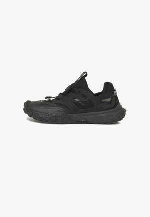 Chaussures de sport noires avec une semelle en caoutchouc texturé, des panneaux en mesh et un bout moulé. Elles présentent un design à lacets avec une languette au talon.