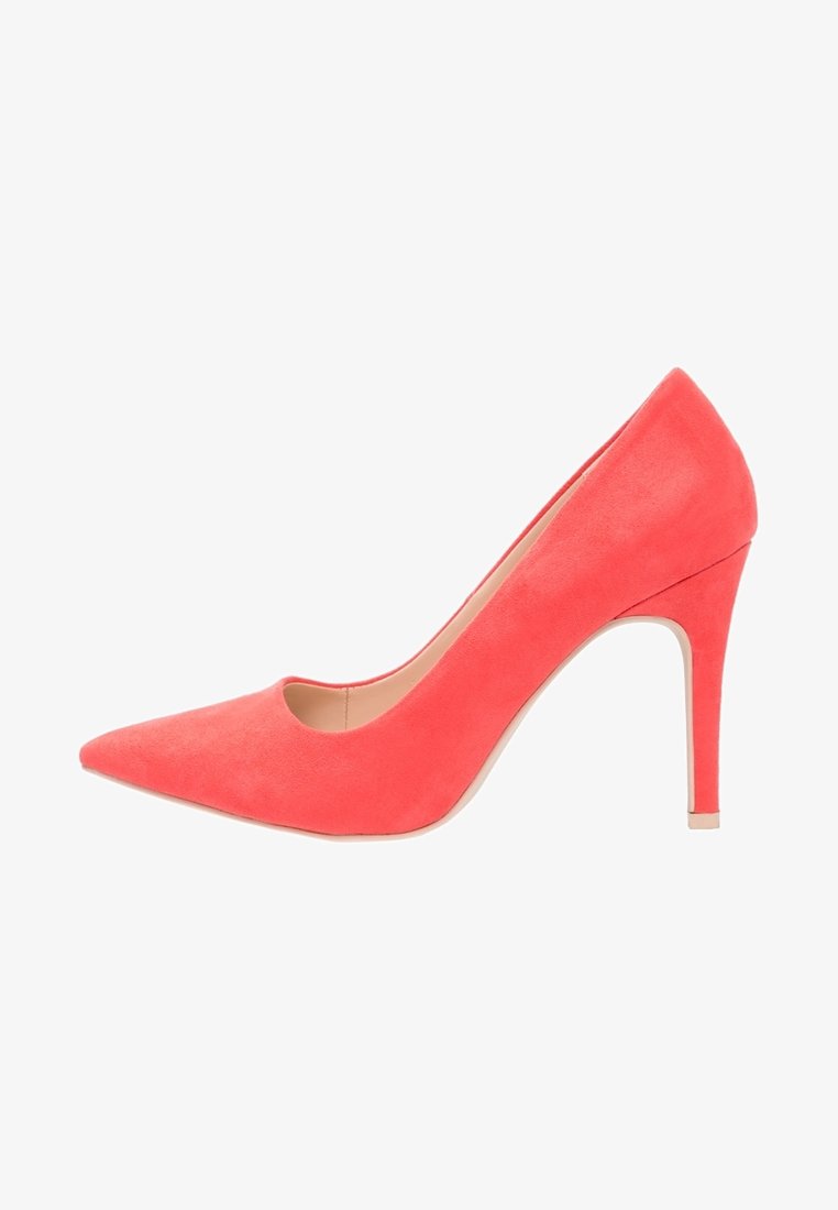 Escarpin en daim rose corail à talon haut avec bout pointu et talon aiguilles mince sur fond blanc.