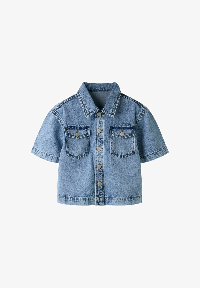 Veste en jean bleu clair à manches courtes avec col, fermeture boutonnée sur le devant et deux poches poitrine à boutons, présentée sur fond blanc.