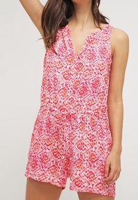 Combinaison sans manches colorée avec un motif géométrique rose et orange, un décolleté en V et une taille cintrée avec un détail à cordon.