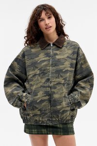 Camouflagejas van denim, met een corduroy kraag, elastische manchetten en een relaxte pasvorm. Patroon bevat tinten groen en zwart.