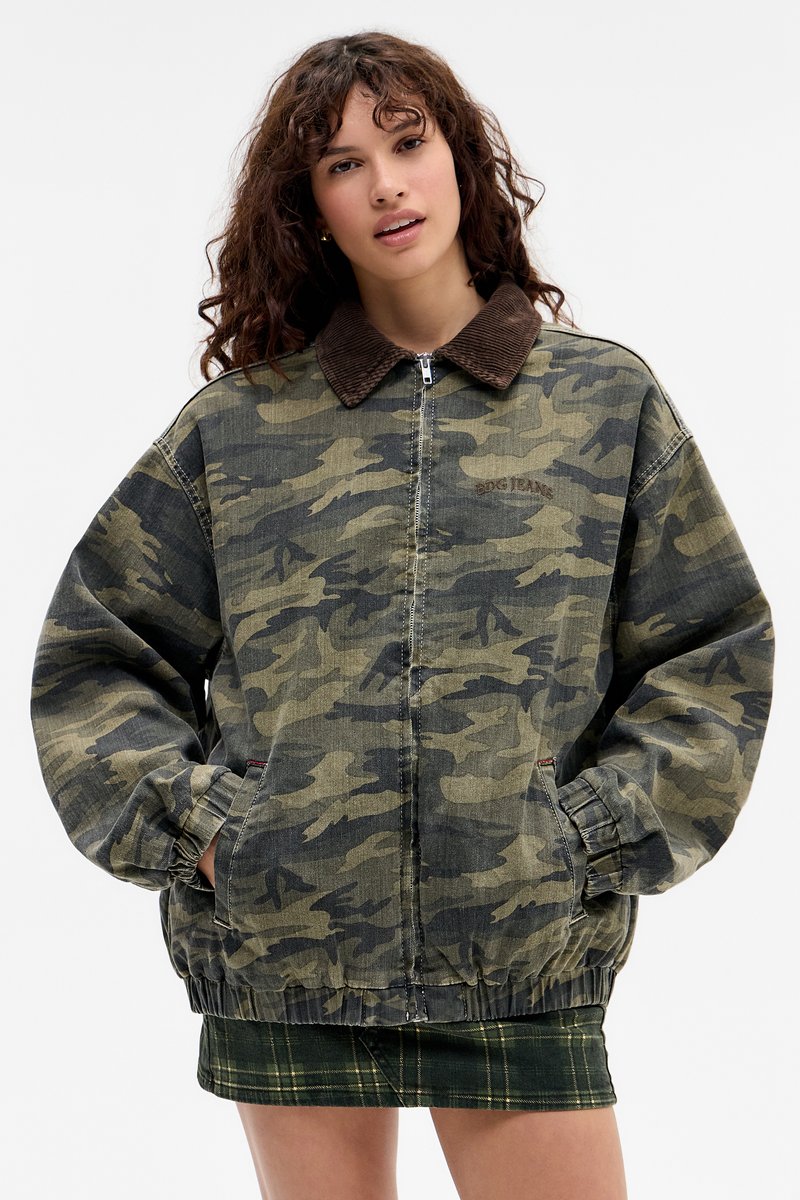 Camouflagejas van denim, met een corduroy kraag, elastische manchetten en een relaxte pasvorm. Patroon bevat tinten groen en zwart.