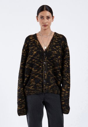 Zwart en geel gebreid vest met een V-hals, mouwen van volledige lengte, vier knopen aan de voorkant en geribbelde zoomdetails.