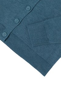 Pull en bleu sarcelle avec une texture lisse, comportant six boutons, des poignets côtelés et un ourlet. Le tissu semble léger et doux.