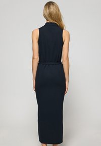 Abito maxi senza maniche di colore blu navy con vita aderente e dettaglio della cintura, caratterizzato da un alto collo e tessuto liscio e elasticizzato.