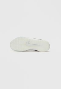 Nike schoenzool met een doorschijnend rubber ontwerp, voorzien van een gestructureerd oppervlak en een opvallend swoosh-logo in een lichte grijstint.