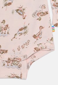 Ljusrosa bodysuit med ett mönster av ankningar i olika poser, med tryckknappsstängning i botten och flerfärgad etikett på sidan.