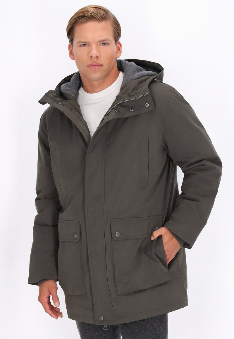 Parka-jakke i mørke olivengrøn, med lynlås og trykknaplukning, to frontlommer og en grå hætteforing. Glat tekstur, isoleret design.