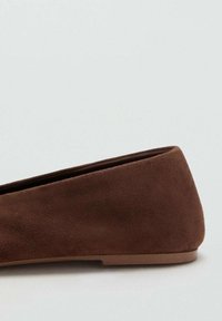 Bruine suede platte schoen met een ronde neus, lage profiel en een gladde textuur. Heeft een minimalistisch ontwerp en een platte rubberen zool.